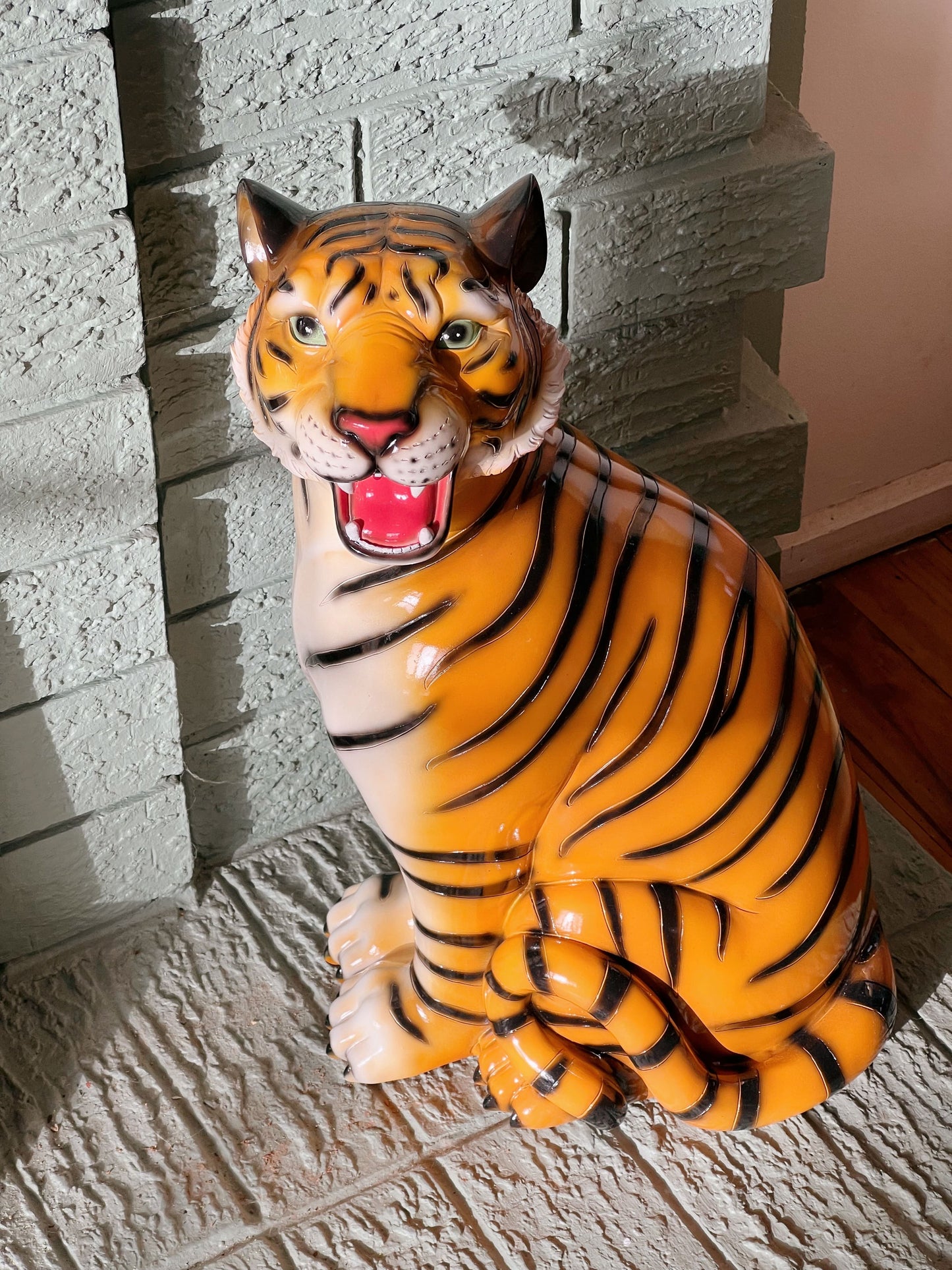 Decorative tiger statue against a brick wall.