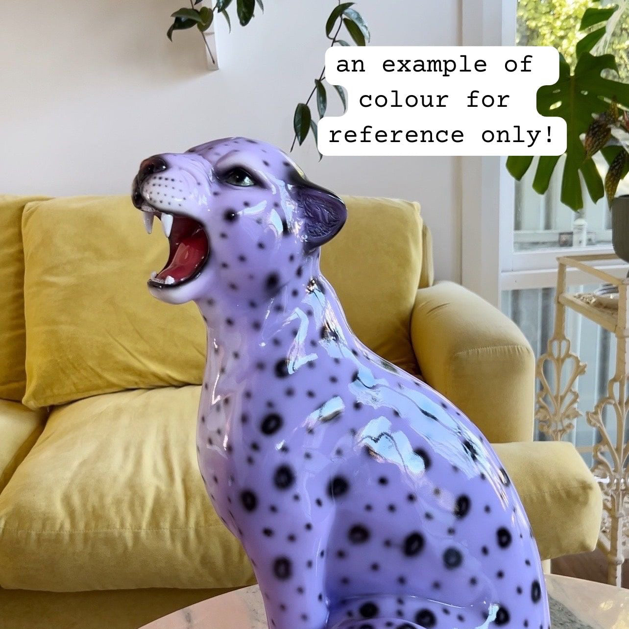 Purple leopard figurine on a table with a yellow couch in the background