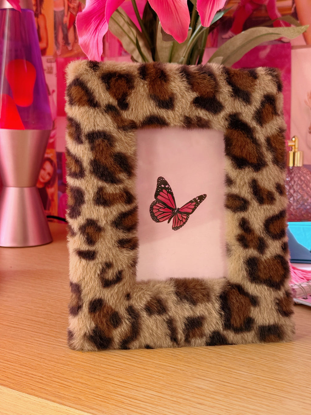 Leopard print photo frame with a butterfly design on a pink background