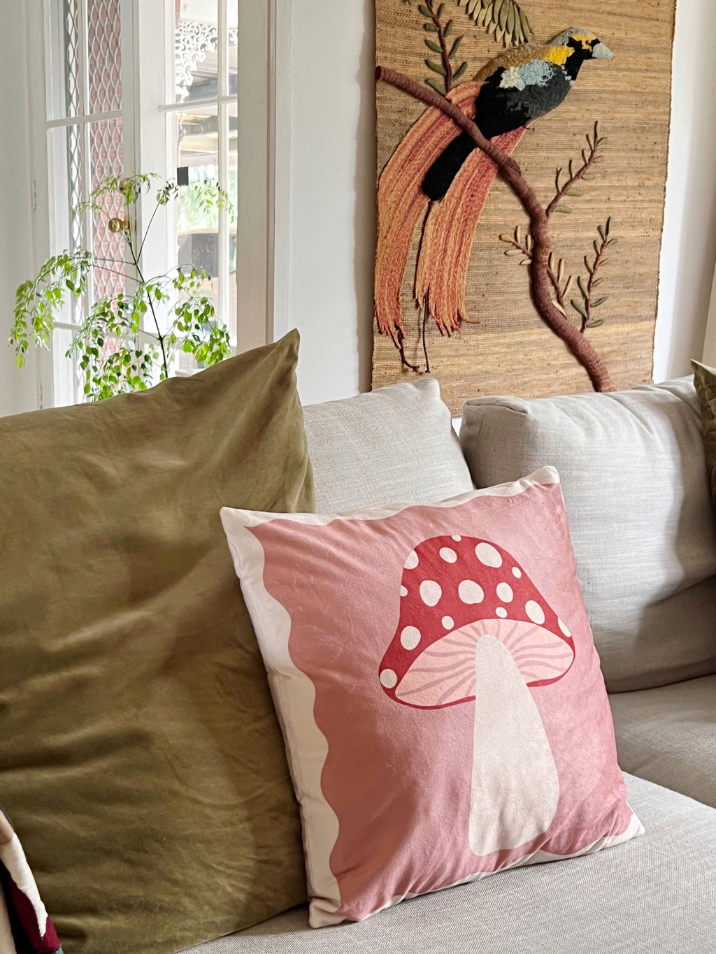 pink and red toadstool cushion displayed on couch in lounge room 