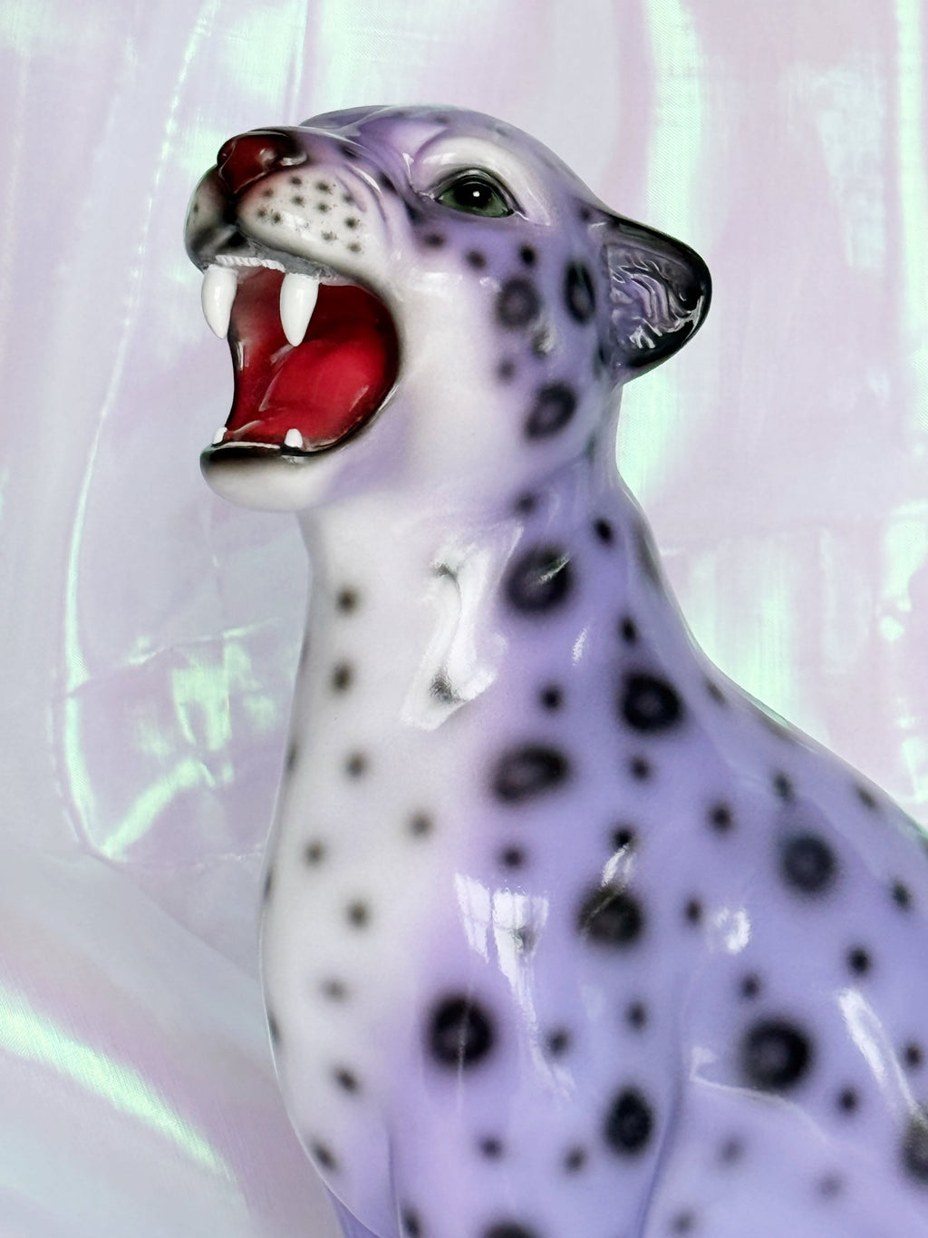 Resin figurine of a leopard with an open mouth on a light background