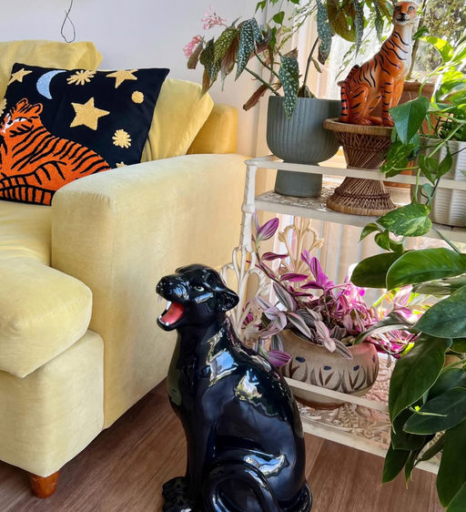 panther statue in front of plants and a yellow couch