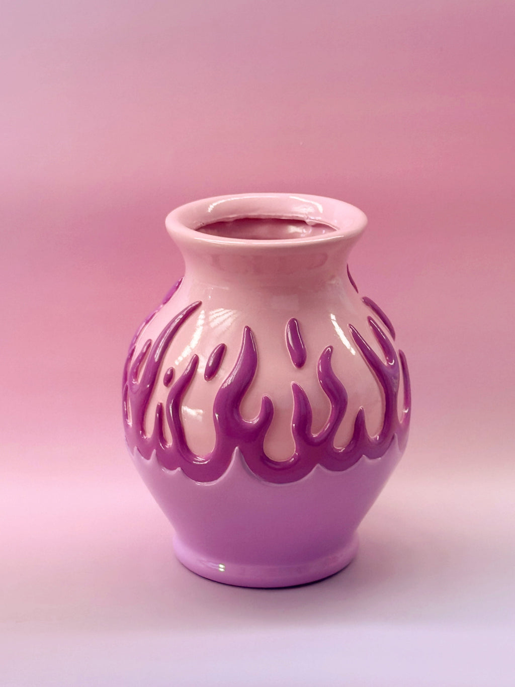 Pink resin vase with flame-like patterns on a pink gradient background