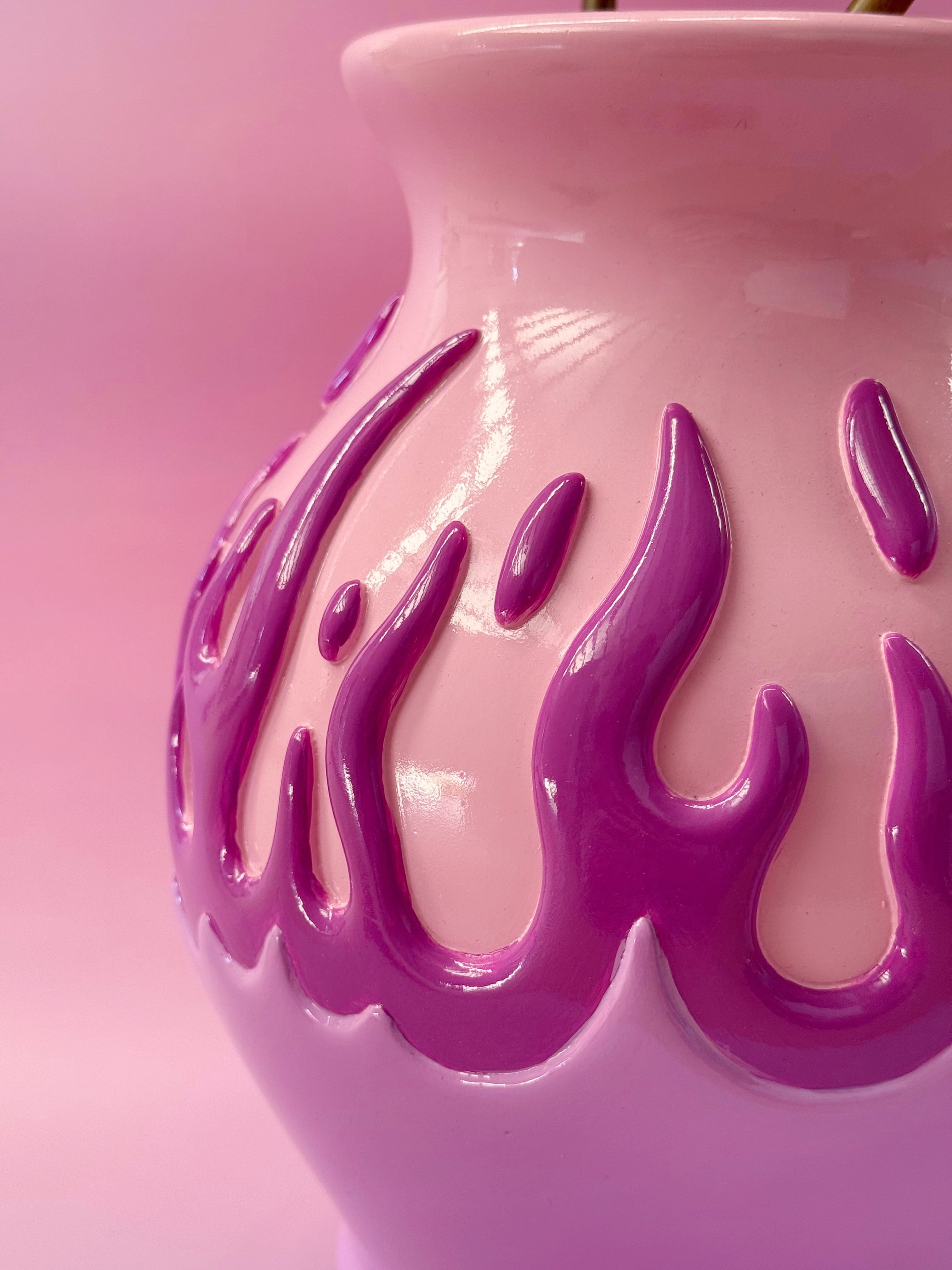 Pink resin vase with purple flame-like patterns on a pink background