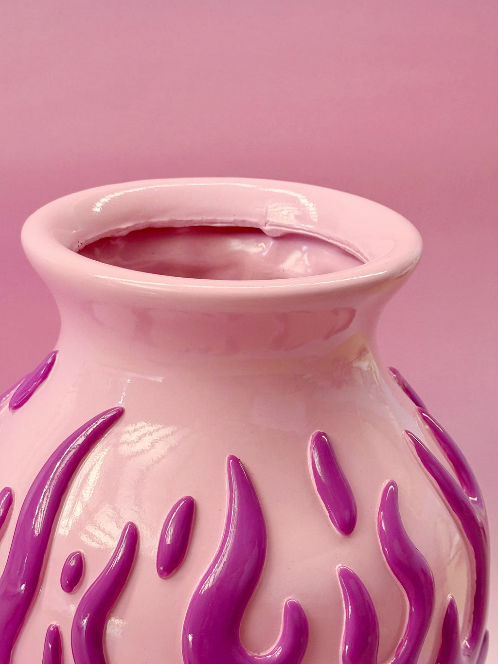 Pink vase with purple flame patterns on a pink background