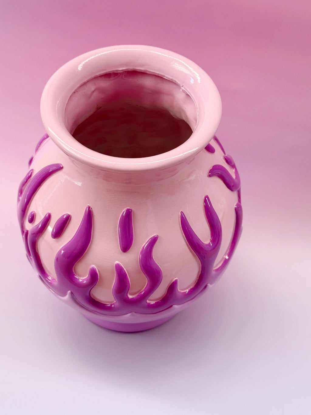 Pink vase with purple flame patterns on a pink background