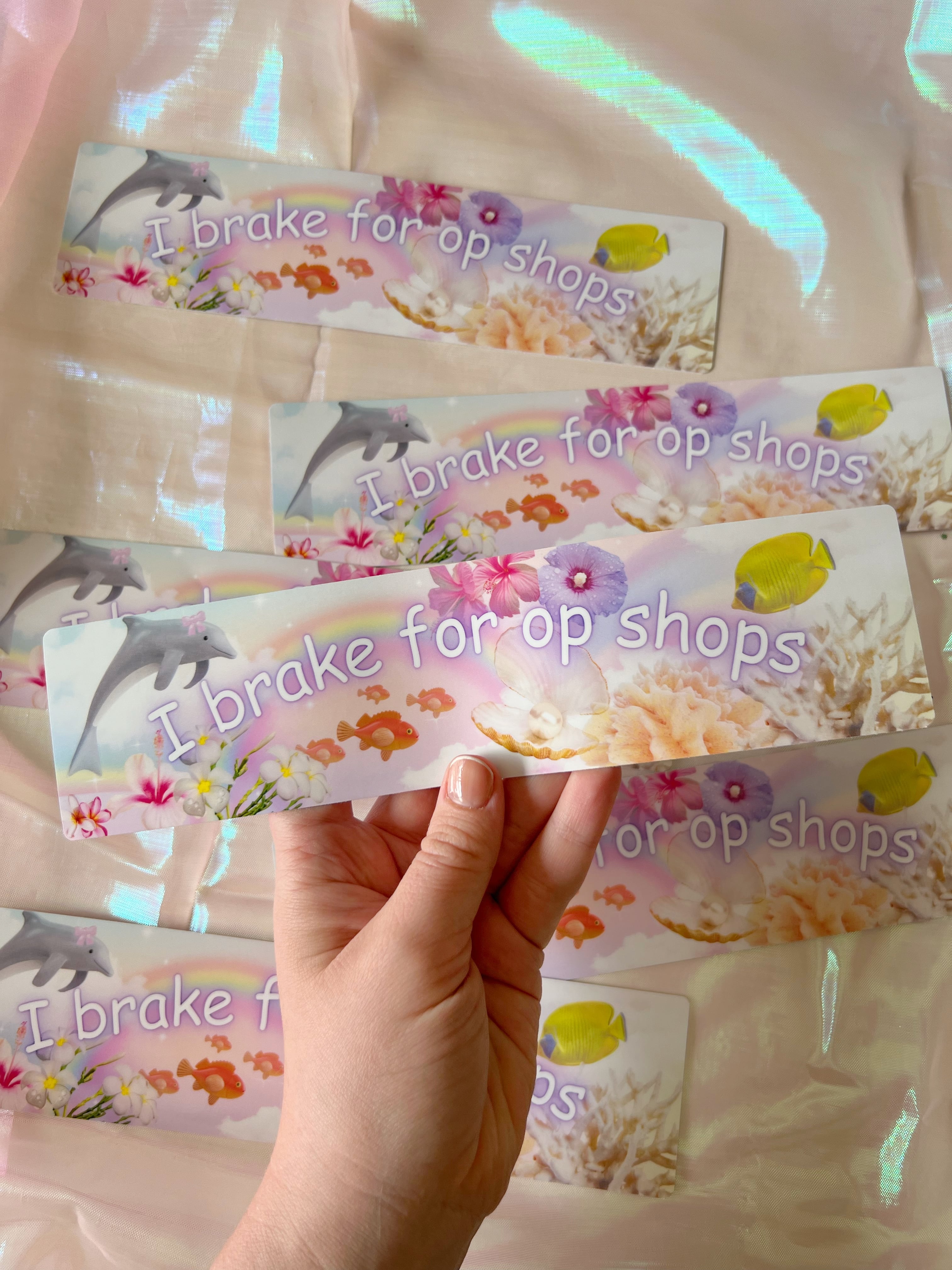 a photo of a hand holding bumper sticker that says "I love trinkets" 