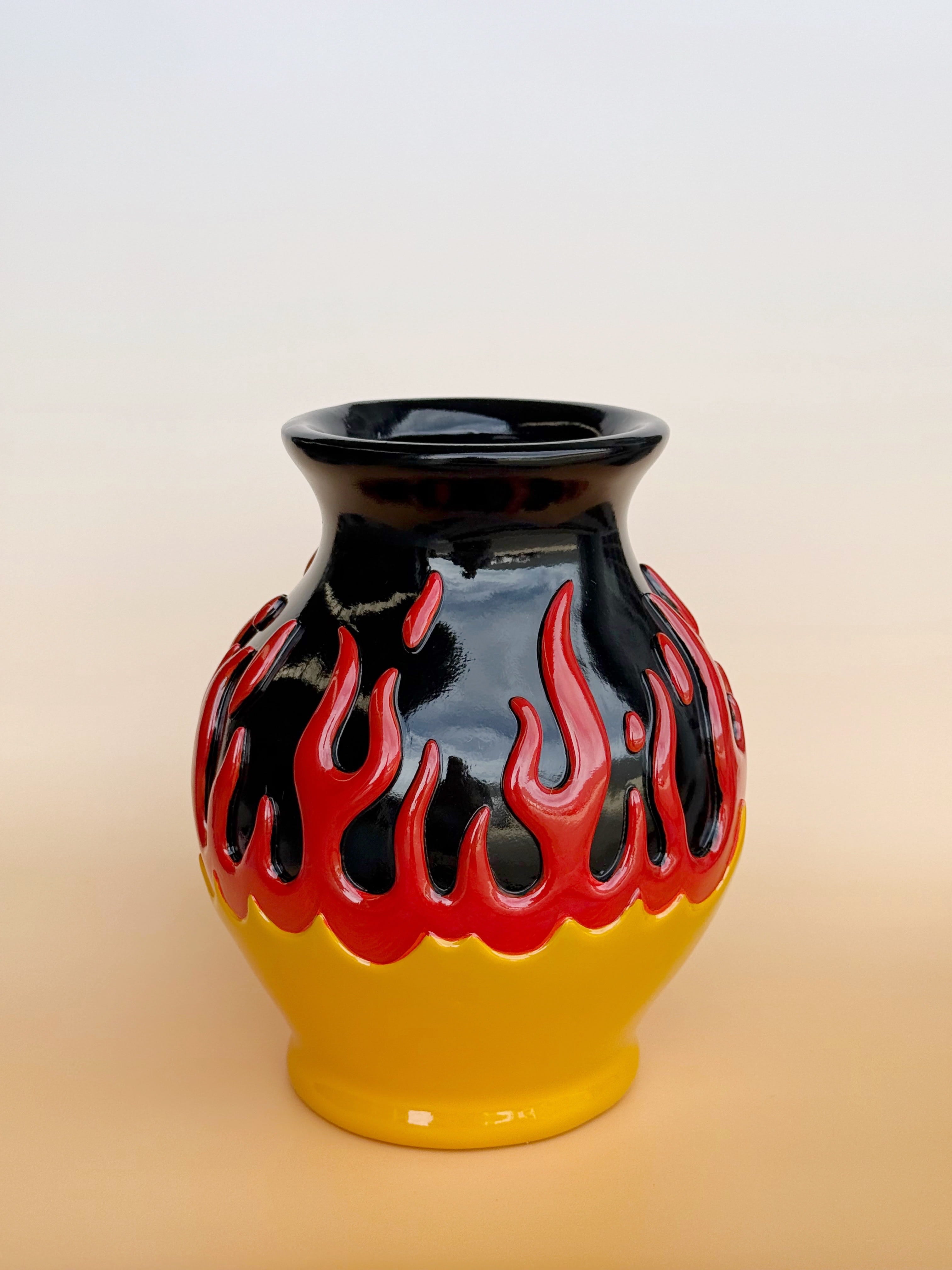 Vase with black and red flame design on a beige background
