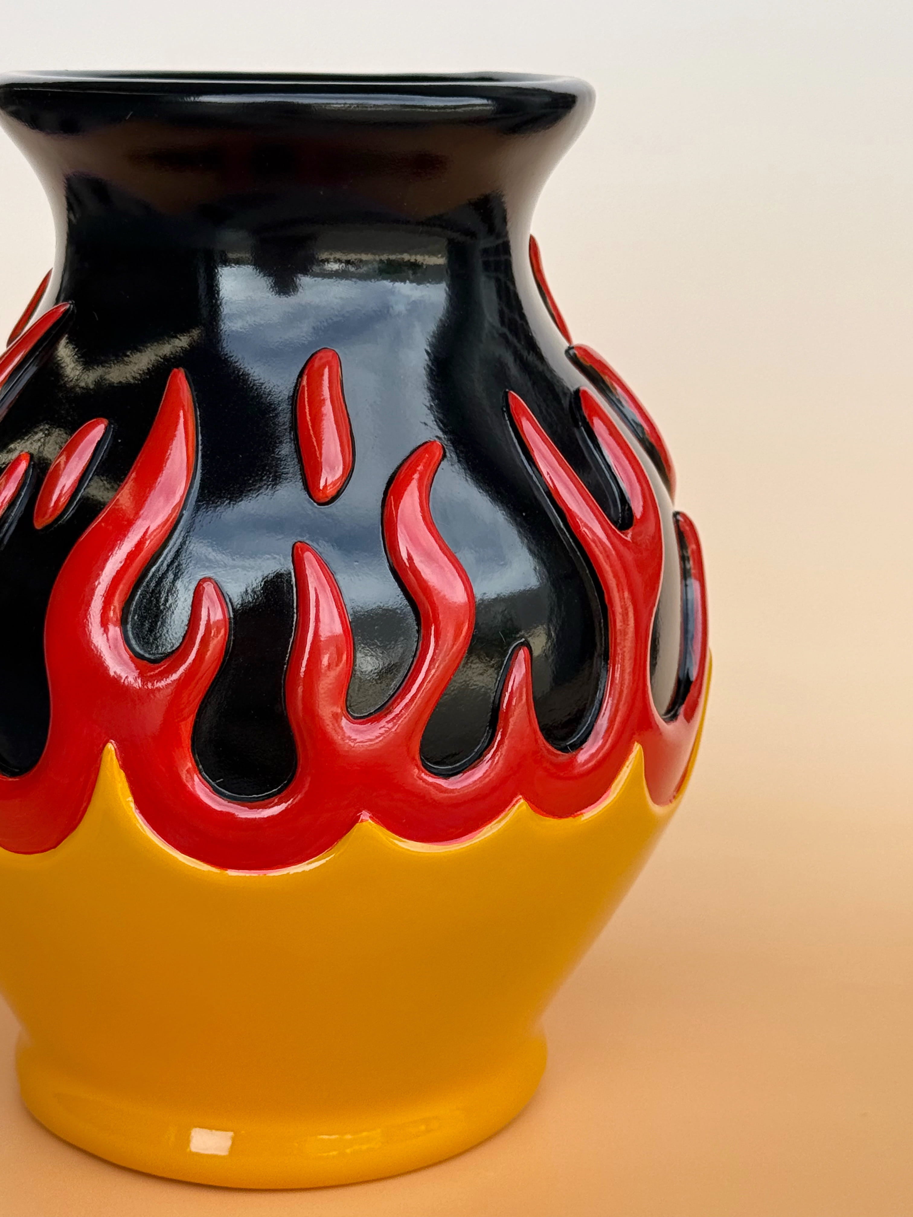 Vase with black and red flame design on a beige background