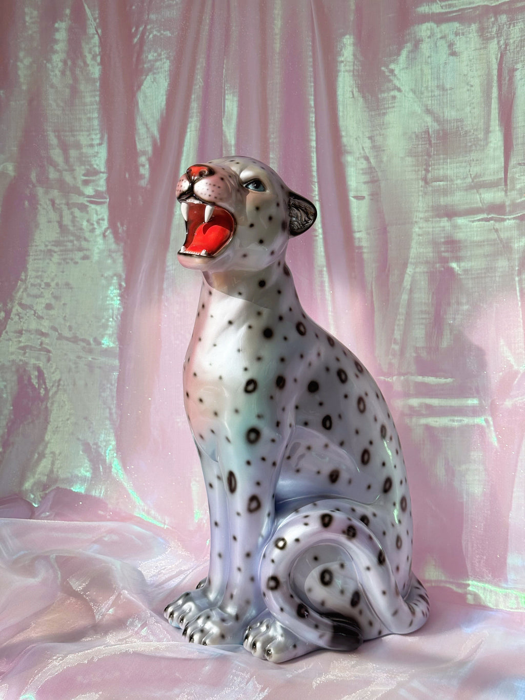 Silvery leopard  figurine on a pink fabric background
