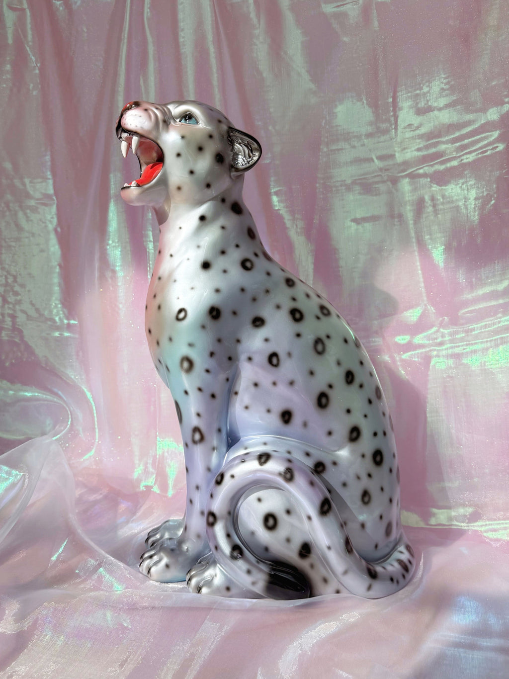 Silvery leopard  figurine on a pink fabric background