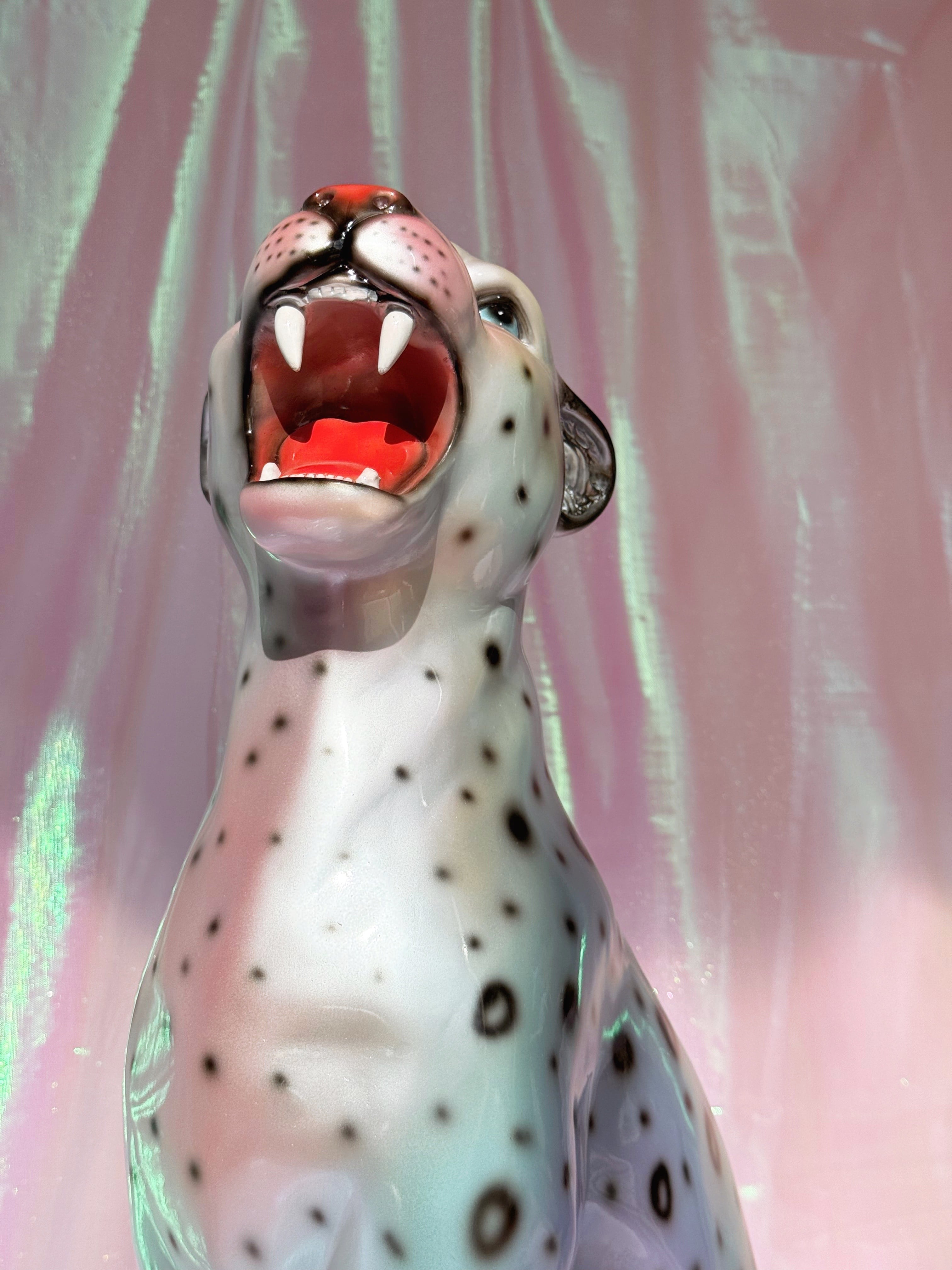 Silvery leopard  figurine on a pink fabric background