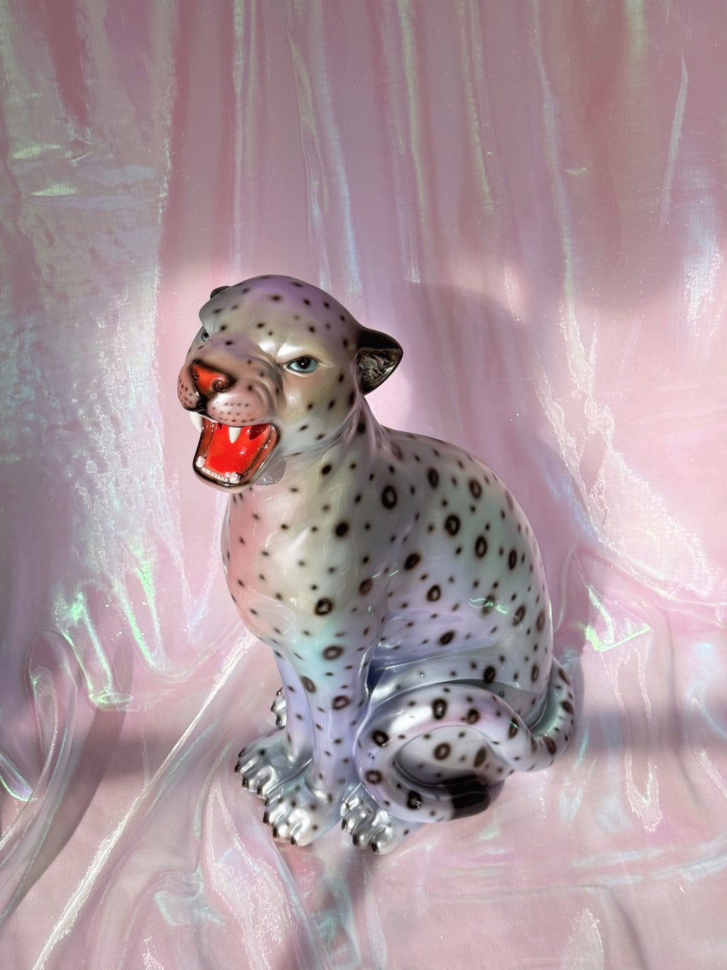 Silvery leopard  figurine on a pink fabric background