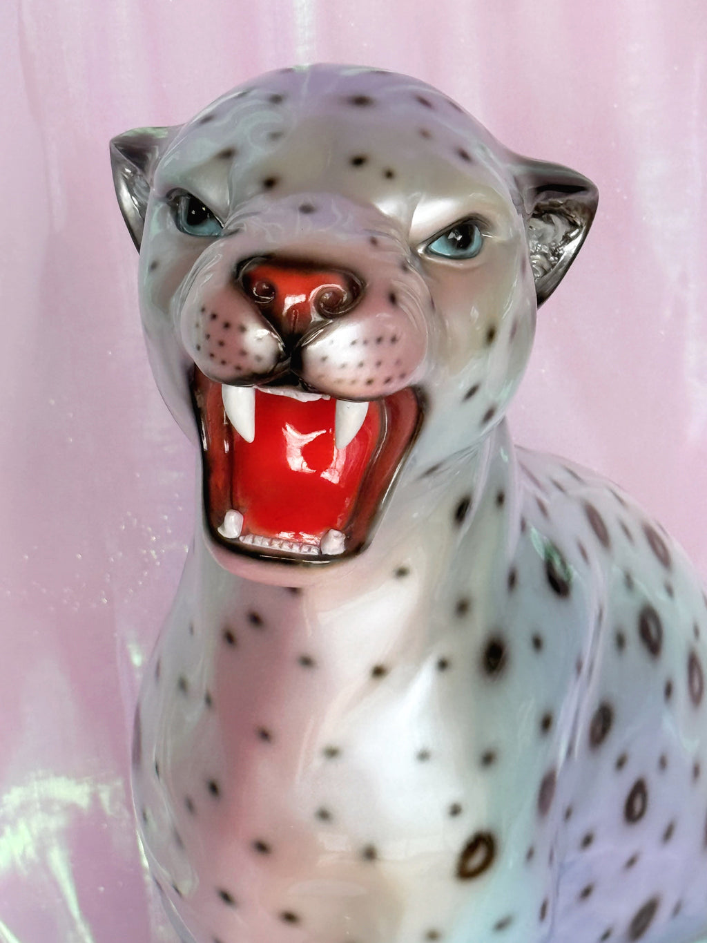 Silvery leopard  figurine on a pink fabric background
