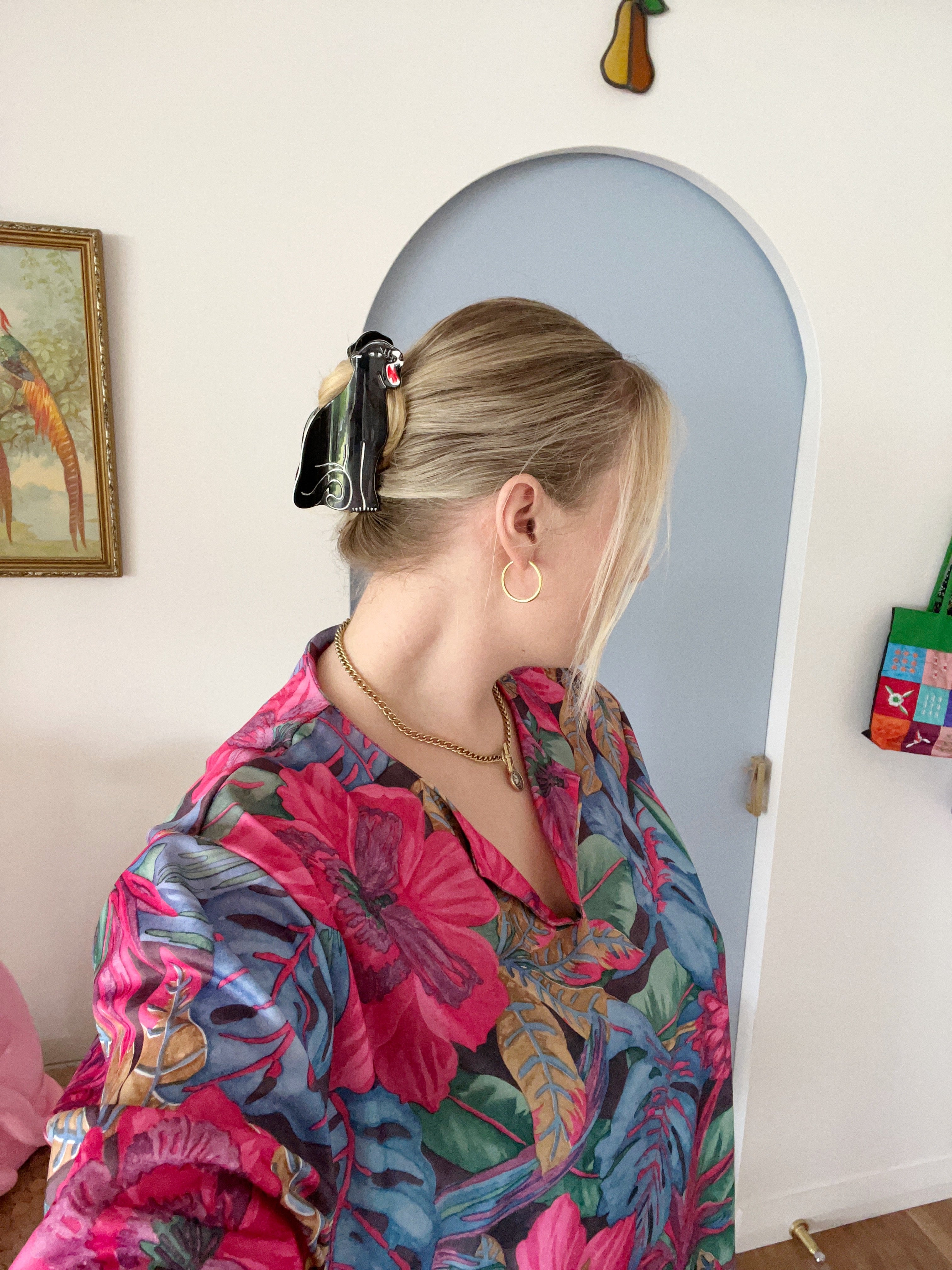 Person wearing a colorful floral dress and panther hair claw clip