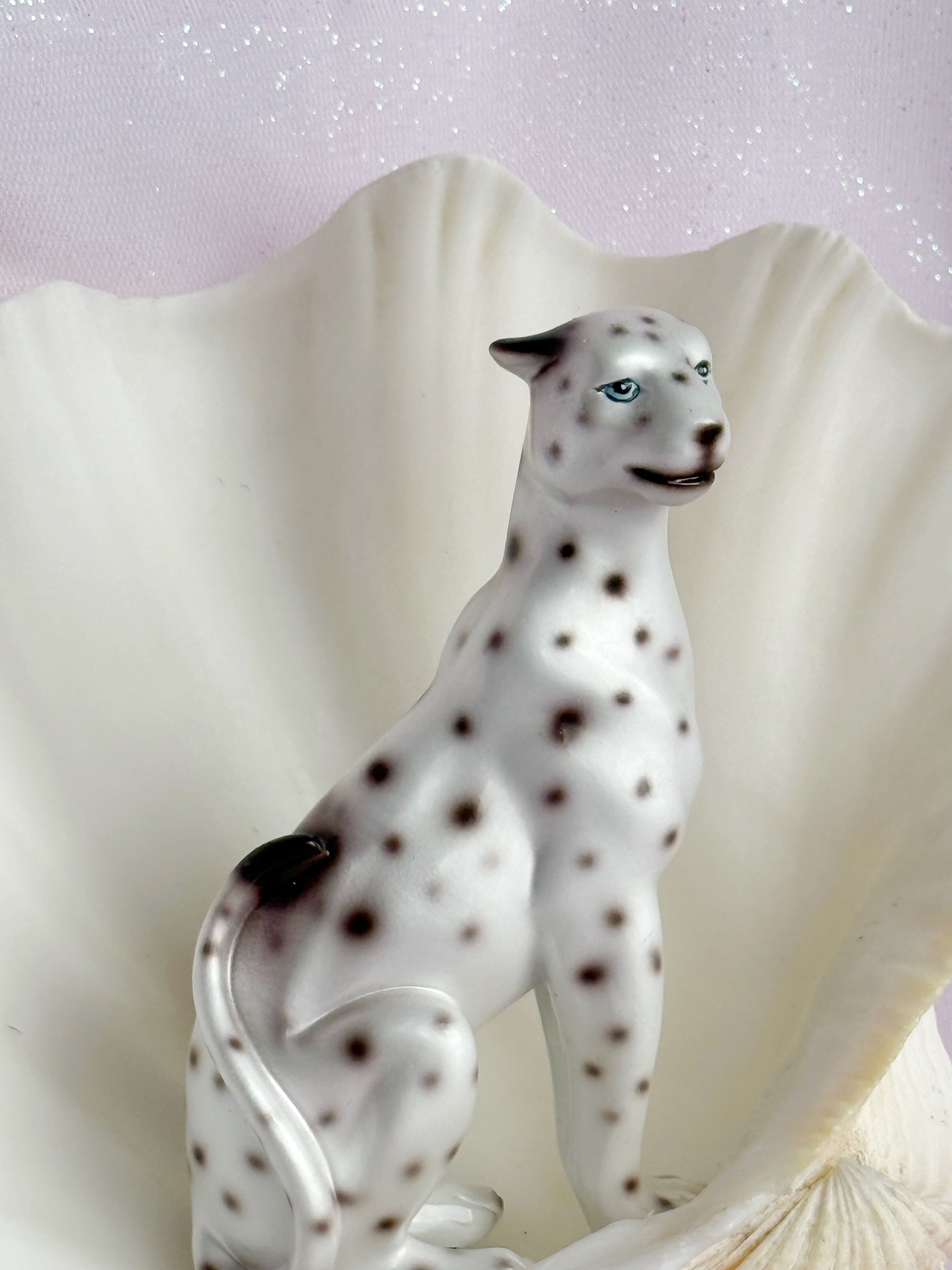 Resin figurine of a spotted leopard on a soft white background