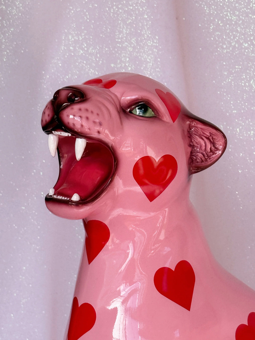 Pink leopard figurine with red hearts on a white background
