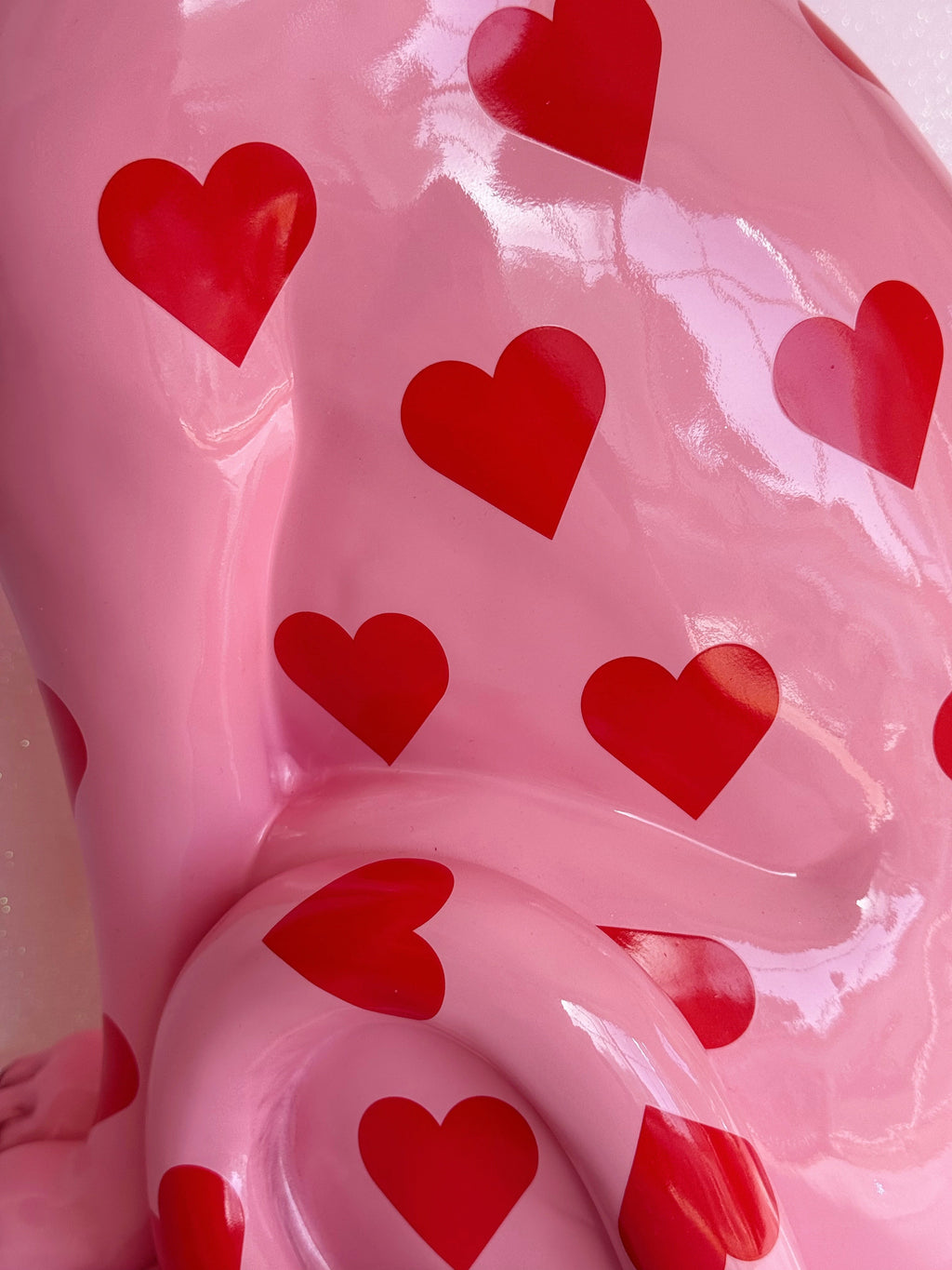 close up of pink leopard figurine with red heart patterns