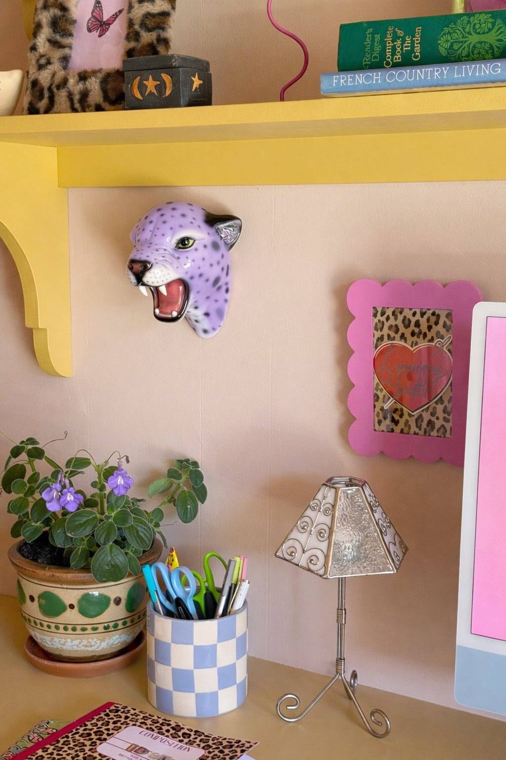 Decorative shelf with leopard-themed items including a lamp, plant, and picture frame.