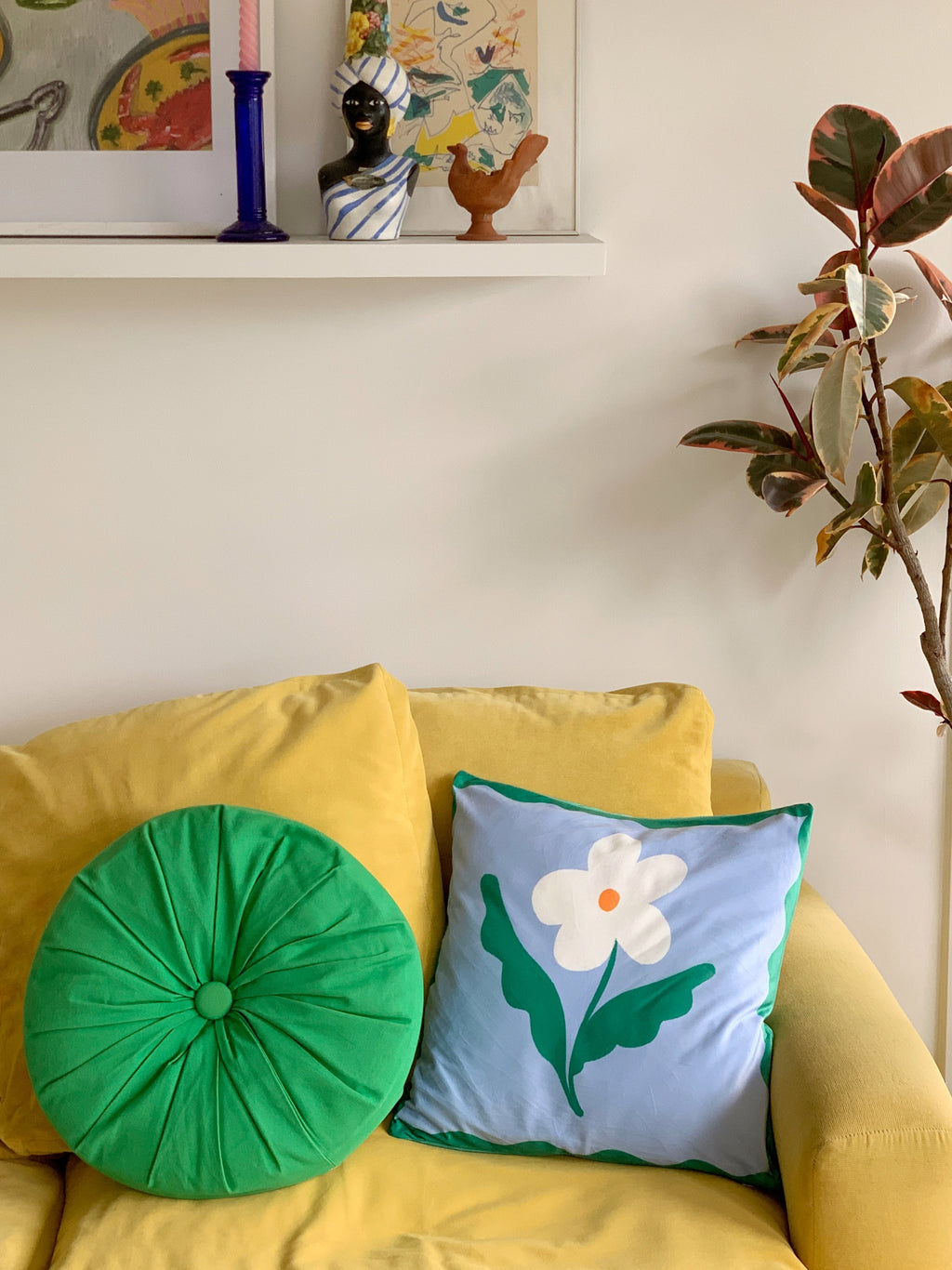 blue daisy cushion displayed on yellow couch