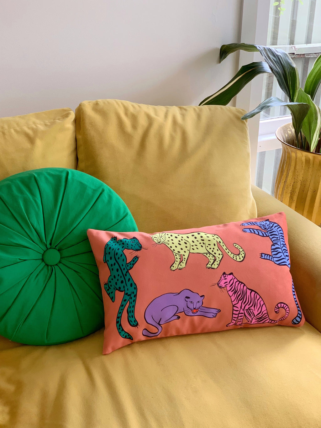 colourful jungle cat cushion displayed on yellow couch