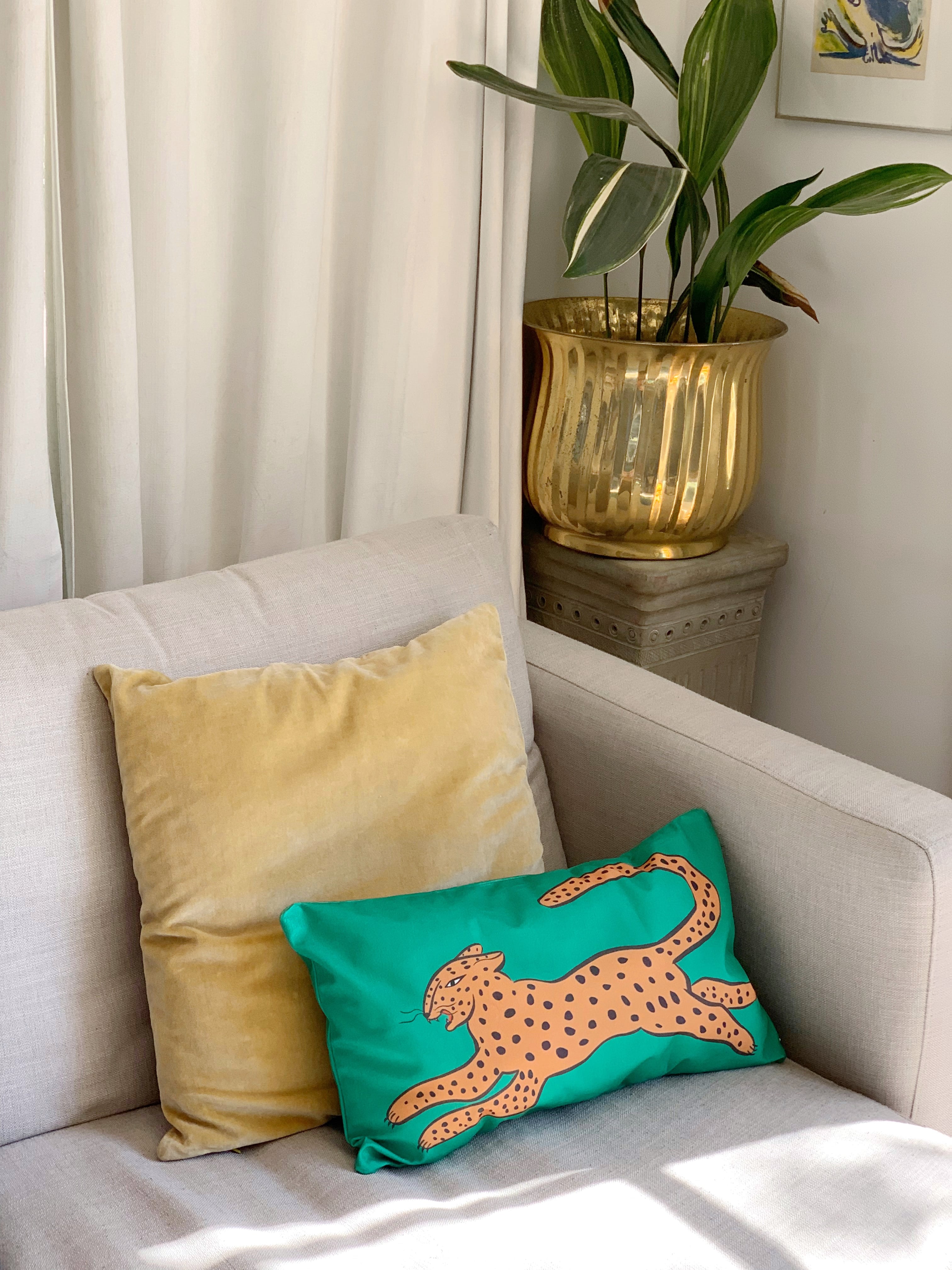 green leaping leopard cushion cover on couch